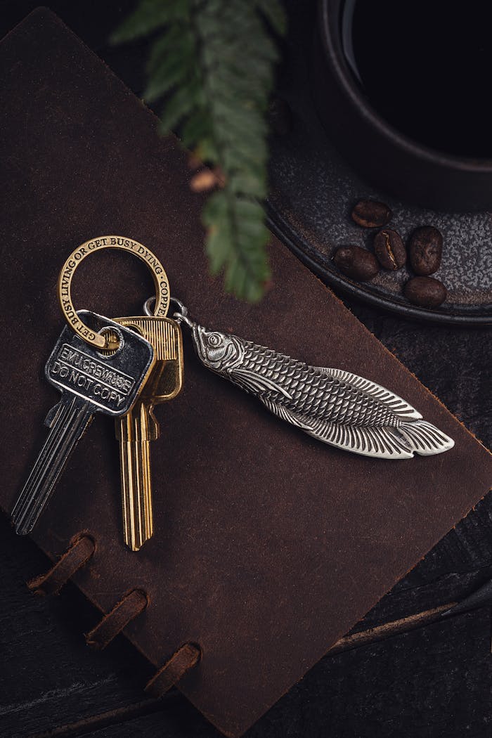 Mastering the First Impression: Your intriguing post title goes here Stylish arowana keychain and keys resting on a rustic journal, paired with coffee beans, creating a vintage aesthetic.